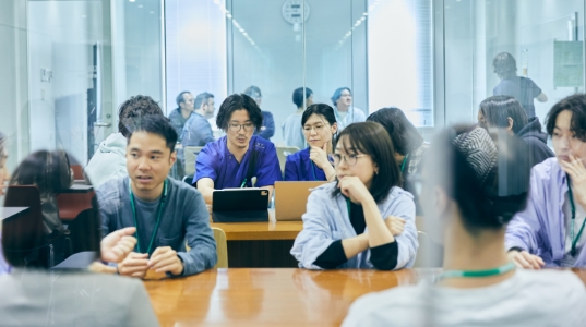 学校内での授業で学生同士が話し合っている様子。