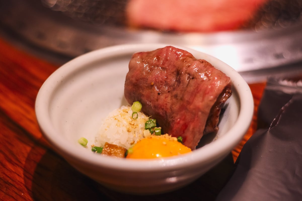 深さのある小皿にシャリ玉・黄身・泡醤油・小口ネギ・ごま、その横に折り畳まれたサーロインがある