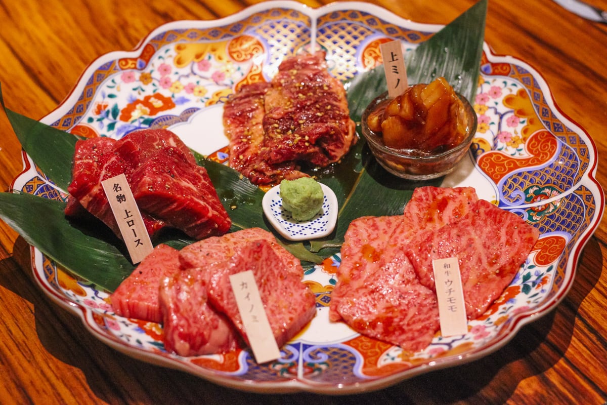 大皿に五種類の肉が並び、中央にわさびが置いてある。時計回り上から、ハラミ（名札なし）・上ミノ・和牛ウチモモ・カイノミ・名物 上ロース