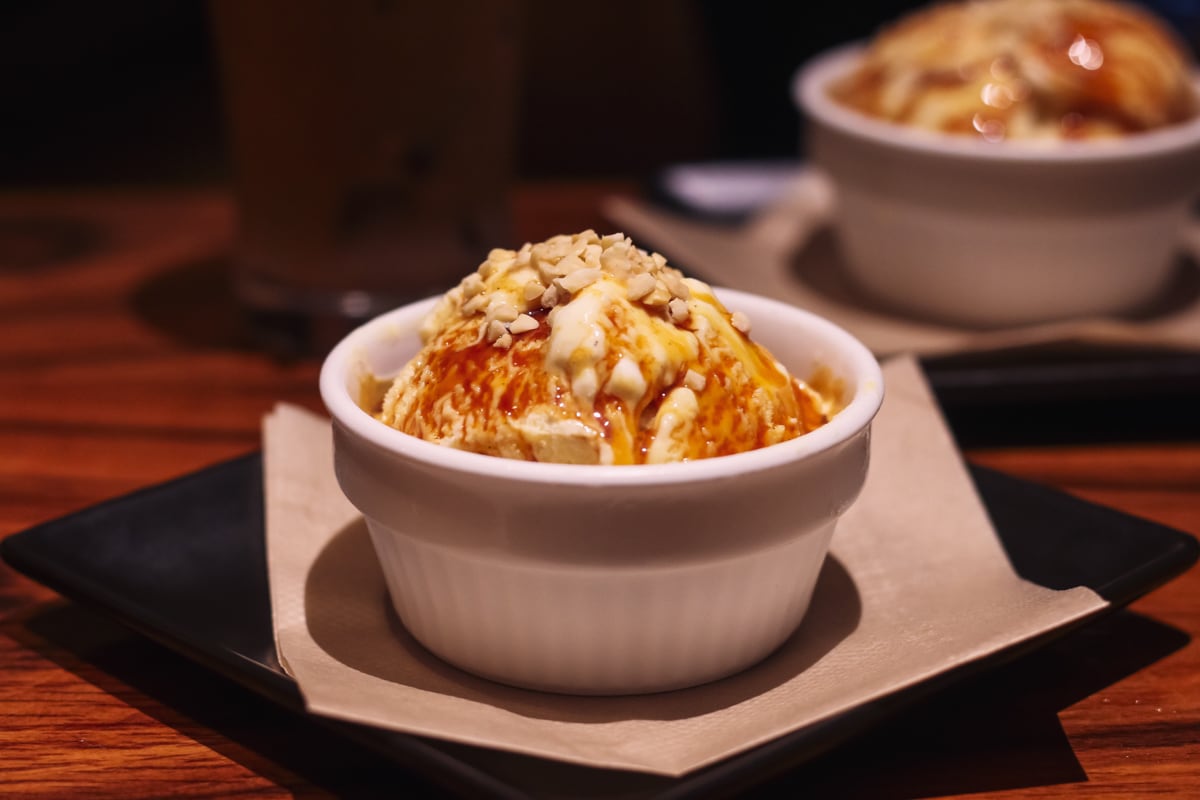 白いココットに盛られたブリュレ、砕いたナッツがトッピングされている